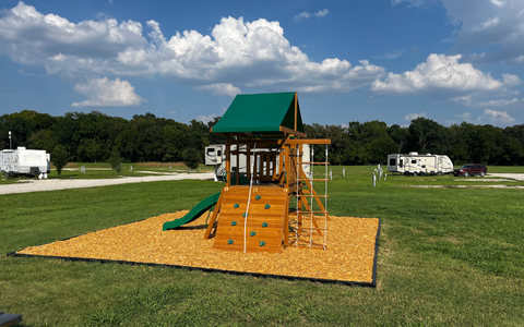 Playground area with slide and climbing structure at Holiday Road RV Park, designed for families and long-term residents