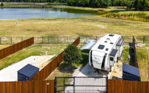 Fenced RV site at Holiday Road RV Park with full hookups, private yard, storage shed, and pond views in Texa